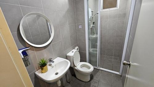 a bathroom with a toilet and a sink and a mirror at Serenestay Cozy Studio @ Southville City in Kajang
