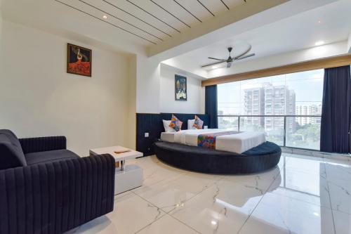 a bedroom with a king sized bed and a couch at FabHotel Bliss in Ahmedabad