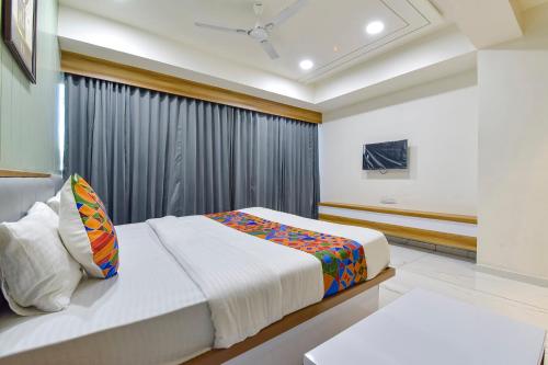 a bedroom with a bed and a window at FabHotel Bliss in Ahmedabad