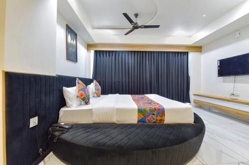 a bedroom with a large bed with a large ottoman at FabHotel Bliss in Ahmedabad