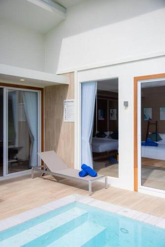 a room with a swimming pool next to a house at Vann House Chiang Rai- near Mae Fah Luang University in Chiang Rai