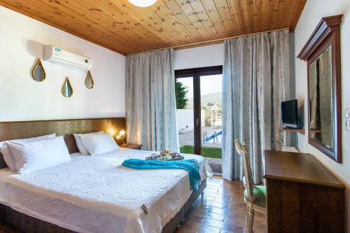 a bedroom with a bed and a large window at Four Seasons Villas in Skiathos Town