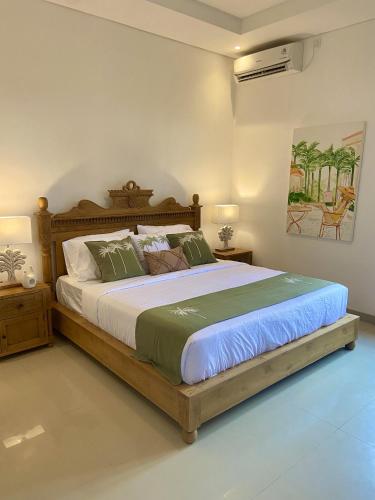 a bedroom with a large bed with a wooden frame at Villa Solas Legian in Legian