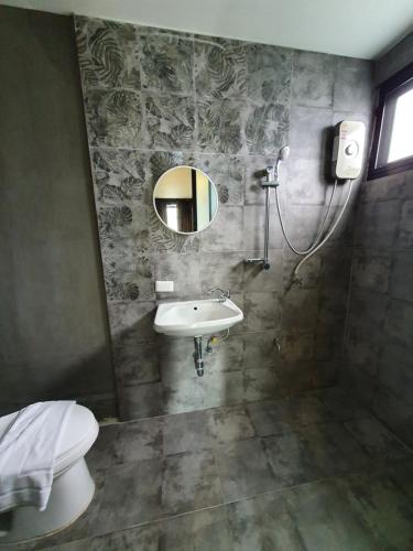 a bathroom with a sink and a mirror and a toilet at Baan Wualamphong บ้านวัวลำพอง in Bangkok