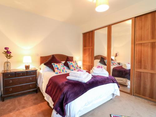 een slaapkamer met 2 bedden en een spiegel bij Abbey View Farm Cottage in Uttoxeter
