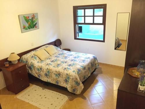 Schlafzimmer mit einem Bett und einem Fenster in der Unterkunft Chácara Restinga Verde - São Roque / SP in São Roque