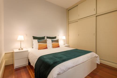 a bedroom with a large bed and two lamps at Discovery | Porto-Flores in Porto