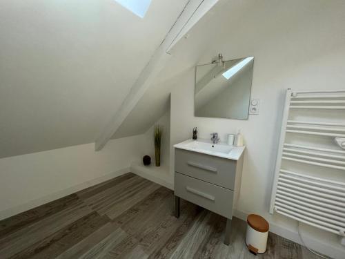 een badkamer met een wastafel en een spiegel bij La Petite Maison in Châteaubriant