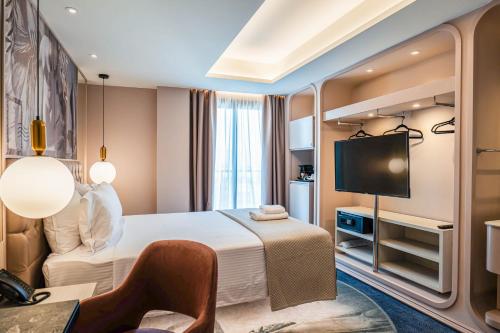 a hotel room with a bed and a flat screen tv at Gate Twenty Two Boutique Hotel in Nicosia