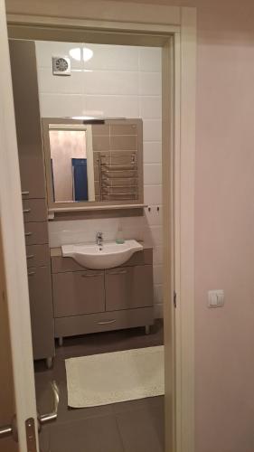 een badkamer met een wastafel en een spiegel bij Airport-apartament 24&24 Chişinău!!! in Chişinău
