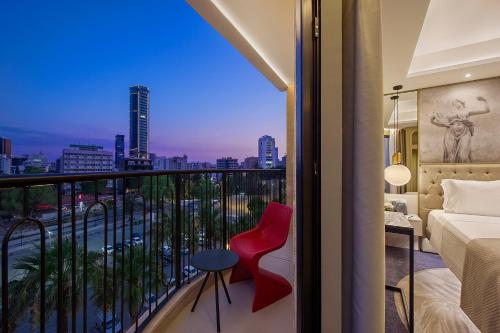 a bedroom with a balcony with a view of a city at Gate Twenty Two Boutique Hotel in Nicosia