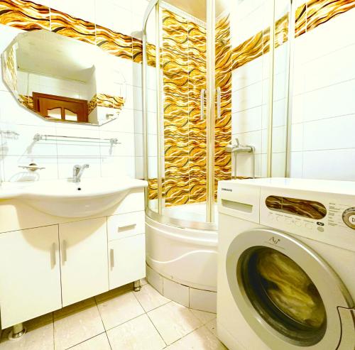 a bathroom with a washing machine and a sink at Apartment 44, spacious living area, separate kitchen & 1 bedroom in Ulaanbaatar
