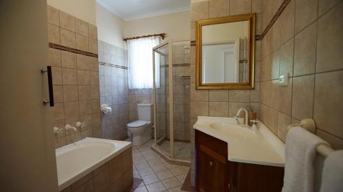 a bathroom with a tub and a sink and a toilet at Southern Ocean Retreats - Deep Creek National Park in Delamere