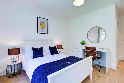 um quarto com uma cama, uma secretária e um espelho em Hybrid Resi - New Malden near Richmond - Wimbledon em Malden