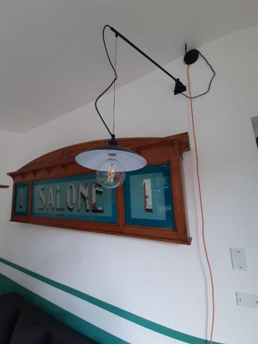 a sign on a wall with a light hanging from it at Le Case di LuVi in Nola