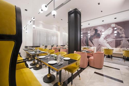 a dining room with tables and yellow chairs at Gate Twenty Two Boutique Hotel in Nicosia