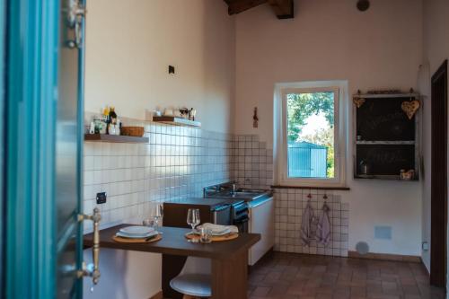 cocina con mesa, fregadero y ventana en Il Girasole, en SantʼIppolito