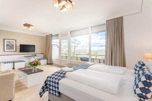 1 dormitorio con cama grande y ventana grande en Ferienwohnungen Strandgrün, en Timmendorfer Strand
