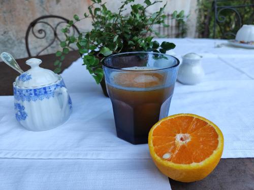 a table with a glass of drink and an orange slice at Casa Lumaca in Tremezzo