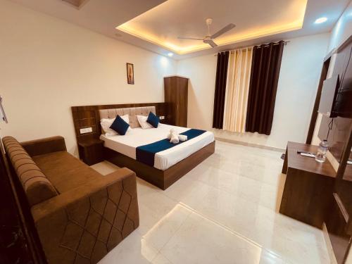 a hotel room with a bed and a couch at The Divine Ganga - Top Rated and Most Awarded Property In Haridwar in Haridwār