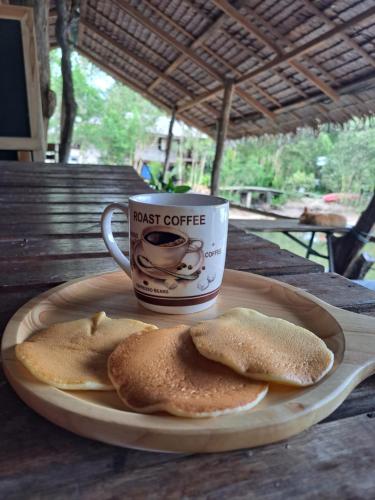una taza de café y dos trozos de pan en un plato en Big Hug Home-Nok kao house, en Ko Yao Noi