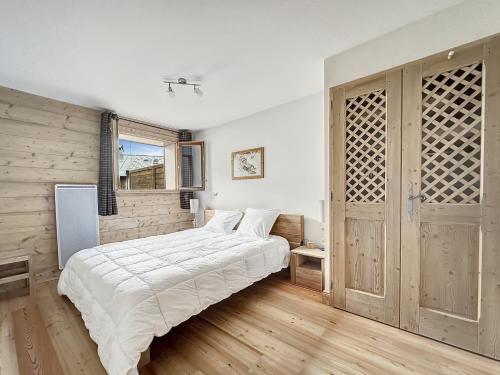 une chambre avec un lit et un mur en bois dans l'établissement rous 03, aux Carroz d'Arâches