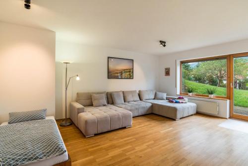 a living room with a couch and a large window at Haus Gartenblick in Annweiler am Trifels
