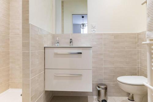 een witte badkamer met een toilet en een wastafel bij Joli T2 Champagne au Mont d'or in Saint-Didier-au-Mont-dʼOr