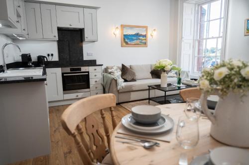 a kitchen and living room with a table and a couch at Bridge View in Annan