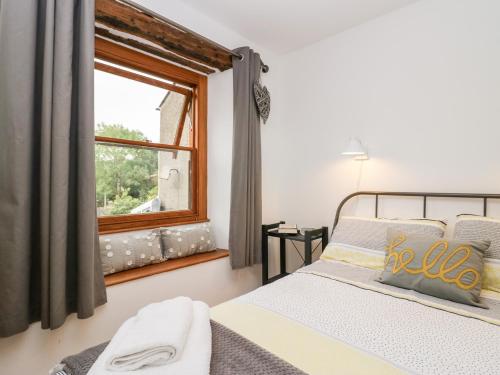 a bedroom with two beds and a window at Jessie's Cottage in Kendal