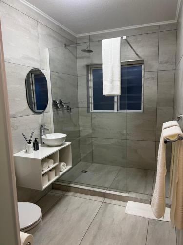 a bathroom with a shower and a toilet and a sink at Tanelsa Apartment on West in Johannesburg