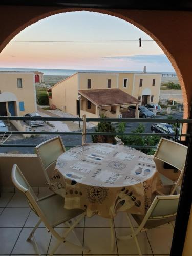 une table et des chaises sur un balcon avec vue dans l'établissement Leucate, à Leucate