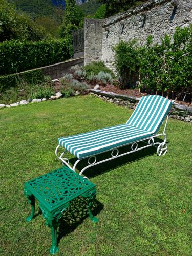 a bench and a table in the grass at Casa Lumaca in Tremezzo