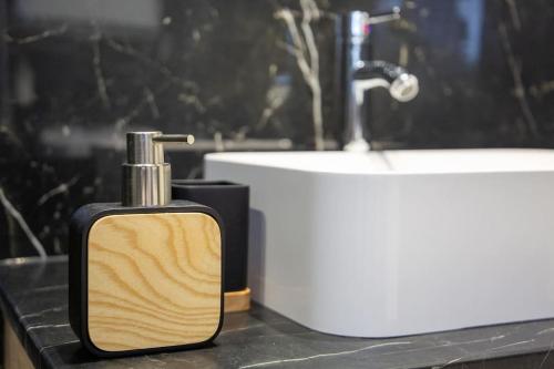 - un distributeur de savon sur un comptoir de salle de bains à côté d'un lavabo dans l'établissement Studio Chaleureux Part-dieu, à Lyon