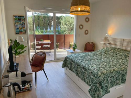 - une chambre avec un lit, une table et un balcon dans l'établissement Studio 11 au Tennis cap d'agde, au Cap d'Agde