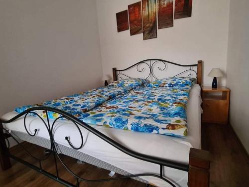 a bed with a blue and white quilt on it at SmartHomeApartman in Hajdúszoboszló