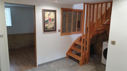 a staircase in a room with a wall with a poster at Charmante maison de pêcheur in Saint-Aubin-sur-Mer