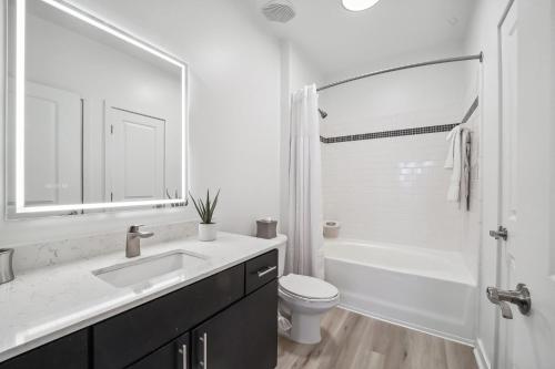 a white bathroom with a sink and a toilet at Premium Apartments and Studios at Midtown 205 in Charlotte in Charlotte