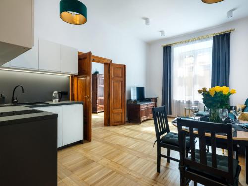 una cucina e una sala da pranzo con tavolo e sedie di Tyzenhauz Apartments Old Town a Cracovia