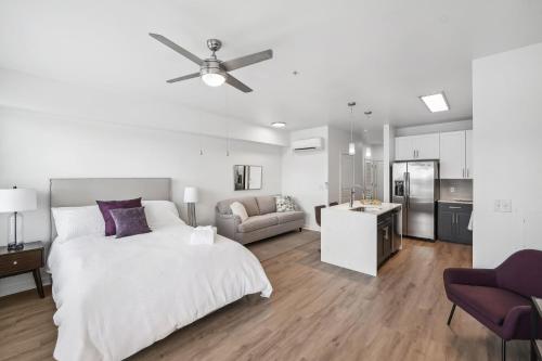 ein weißes Schlafzimmer mit einem Bett und einem Sofa in der Unterkunft Premium Apartments and Studios at Midtown 205 in Charlotte in Charlotte