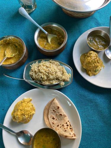 a table with plates of food and bowls of dips at Black Pepper Home Stay in Udaipur
