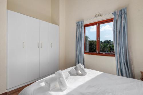 a bedroom with a white bed with a window at San Lameer Villa 2015 - 3 Bedroom Standard - 6 pax - San Lameer Rental Agency in Southbroom
