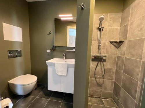 a bathroom with a shower and a toilet and a sink at Hotel Harmonien in Nakskov