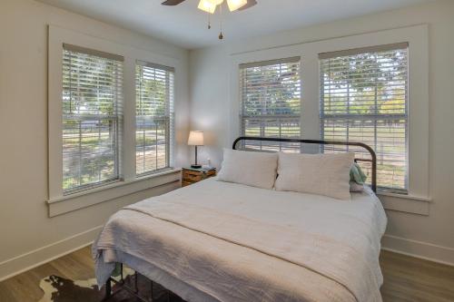 een slaapkamer met een bed en 3 ramen bij Idyllic Country Cottage about 18 Mi to Lake Bridgeport in Decatur
