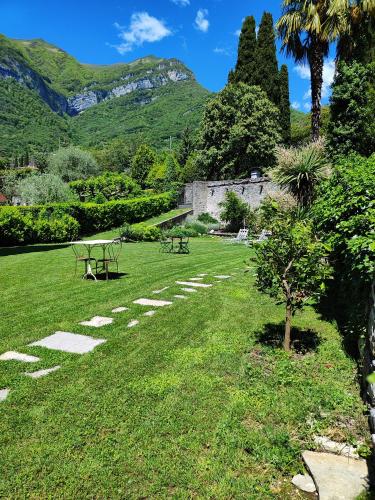 a park with a table and benches in the grass at Casa Lumaca in Tremezzo