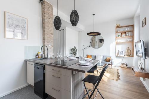 une cuisine avec une table et des chaises dans une pièce dans l'établissement Oh My Gone - Appt en centre-ville de Lyon 6ème, à Lyon