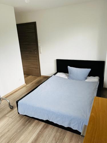 1 dormitorio con 1 cama blanca y suelo de madera en Berufspendler's Rückzug am Golfplatz, en Welzheim