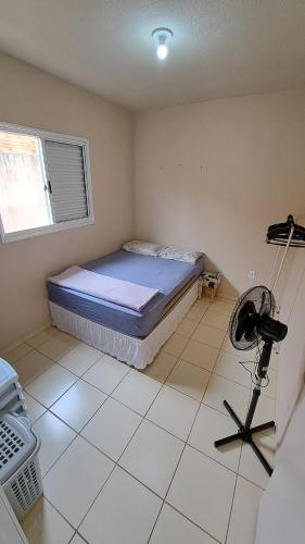 Un dormitorio con una cama y una cámara. en Casa Confortável Mobiliada en Marília