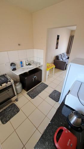 cocina y sala de estar con fogones y sofá en Casa Confortável Mobiliada en Marília