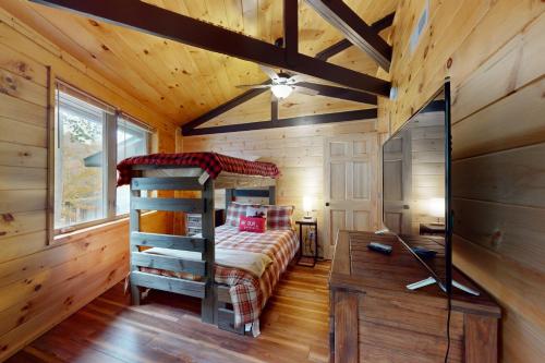 - une chambre dans une cabane en rondins avec un lit et un bureau dans l'établissement Slopesider 20A, à Sugar Mountain